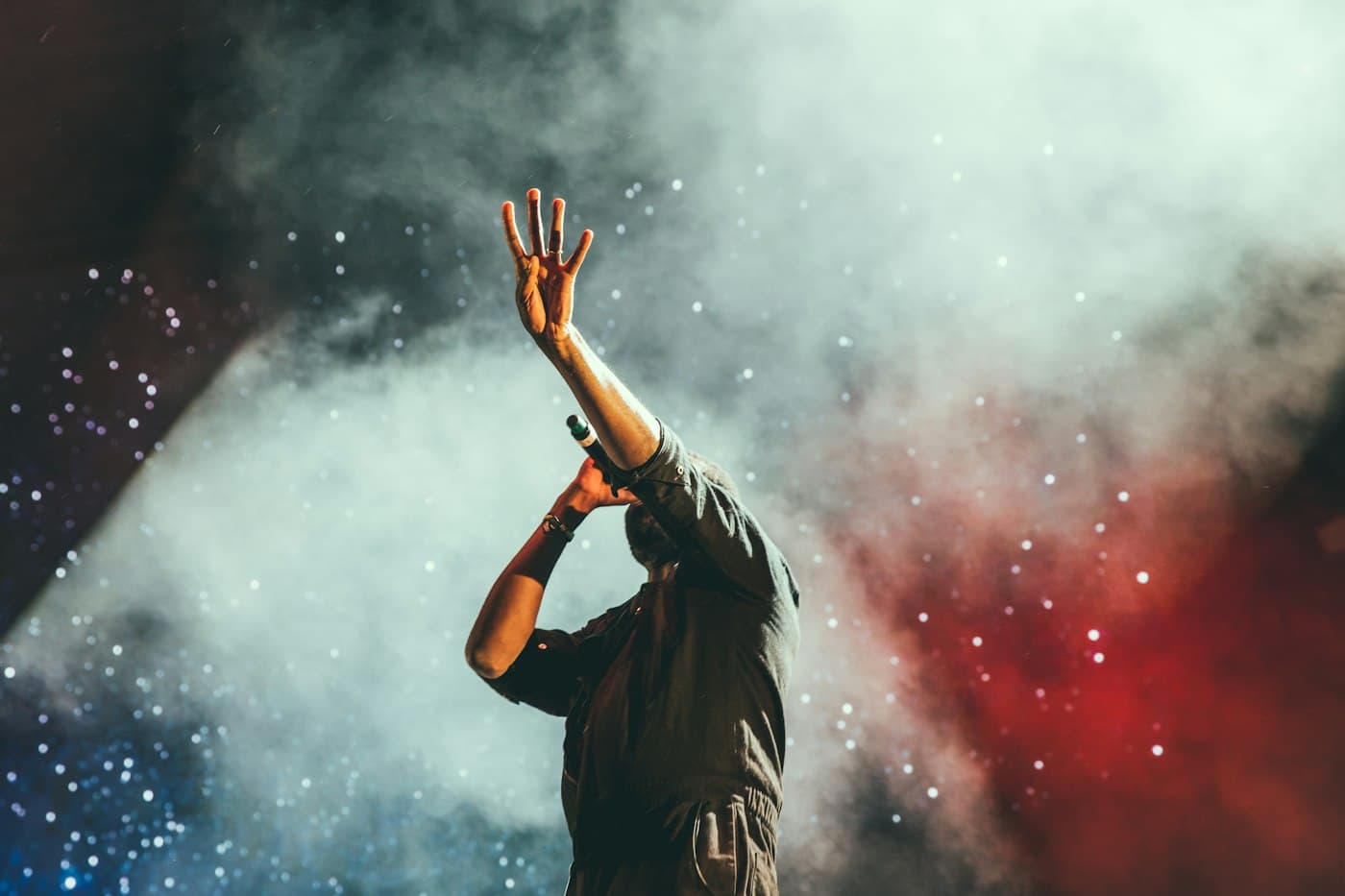 Performer on stage beneath concert lights